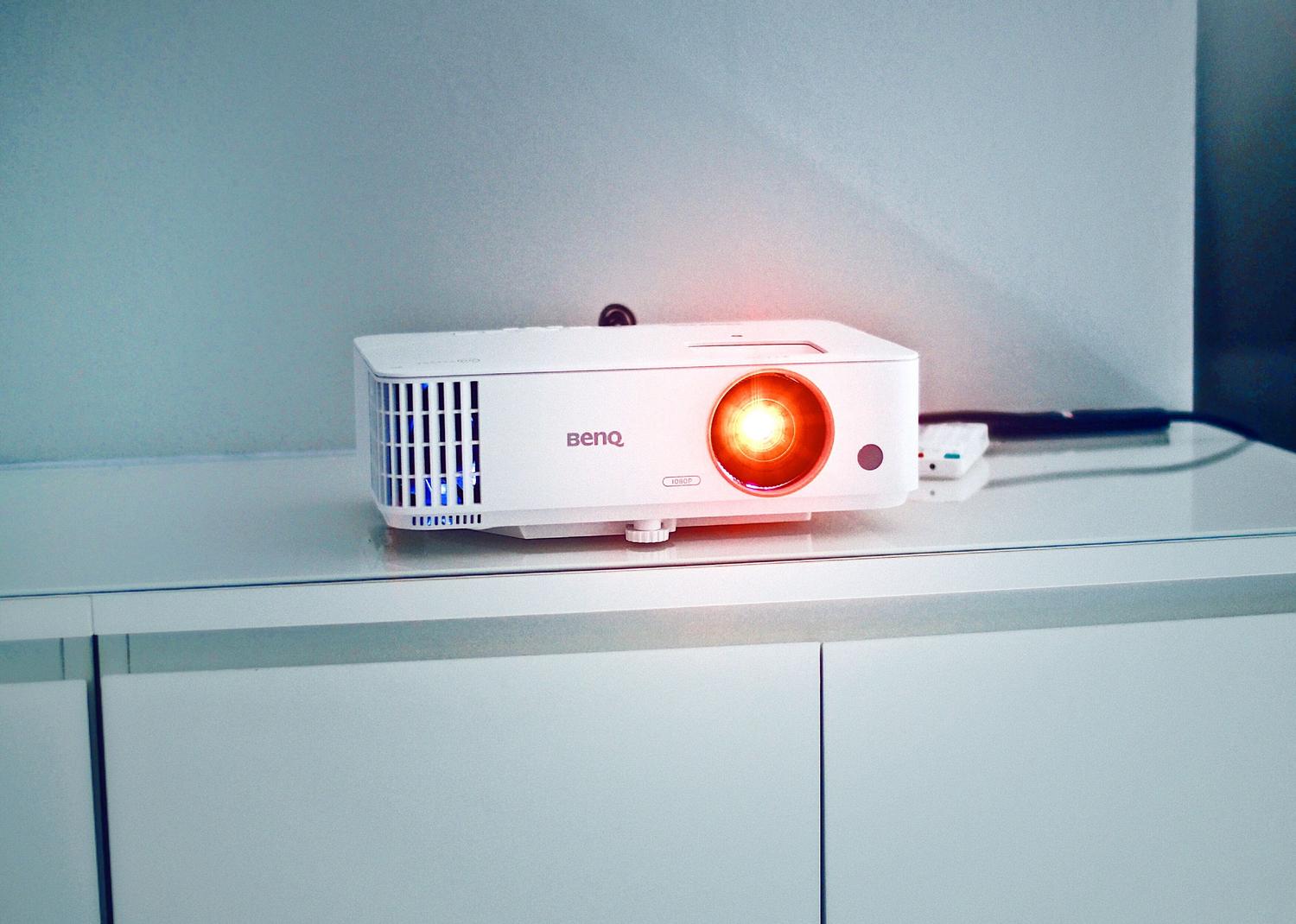 Proyector doméstico moderno sobre un mueble, ilustrando la opción de vídeo para crear una experiencia de cine real en casa.